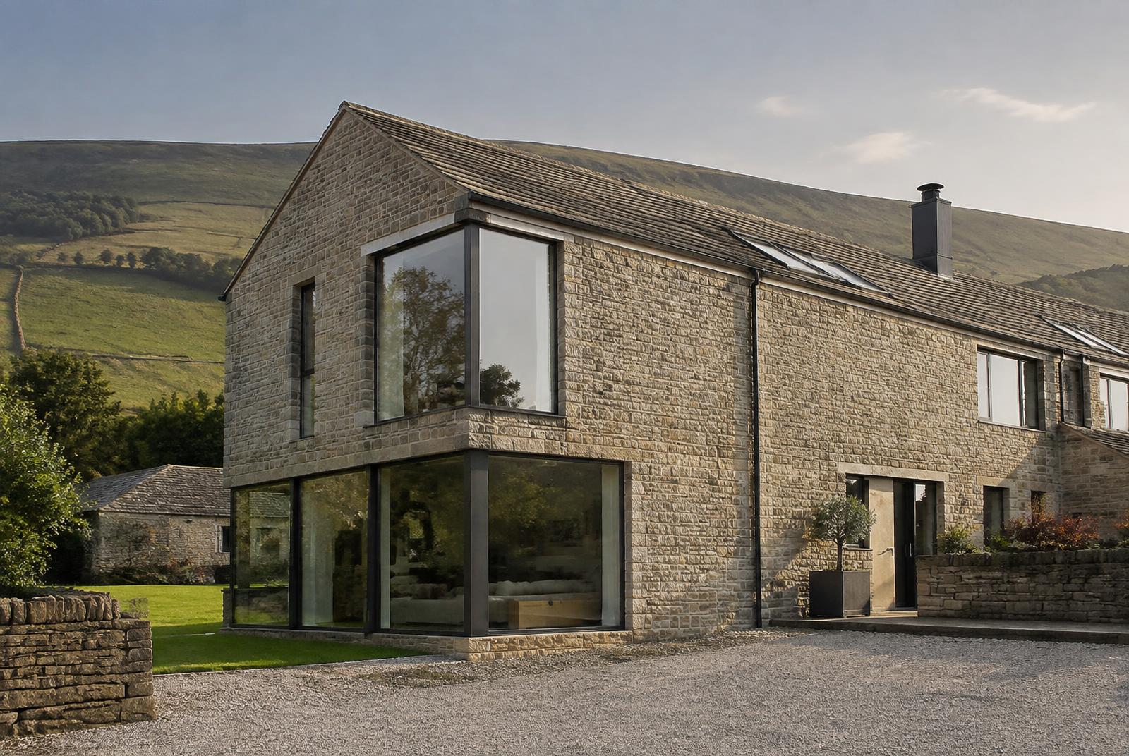 Stone barn conversion with large anthracite aluminium corner windows