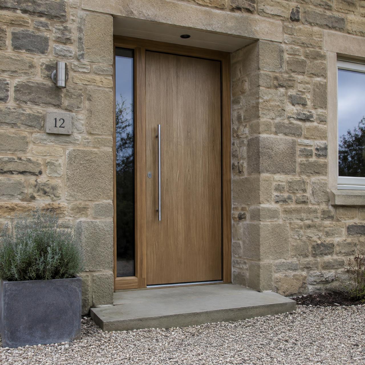 Oak-effect entrance door with glazed sidelight in a stone surround