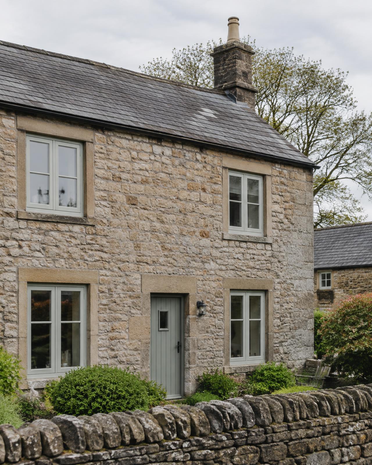 Stone cottage with sage green flush casement windows
